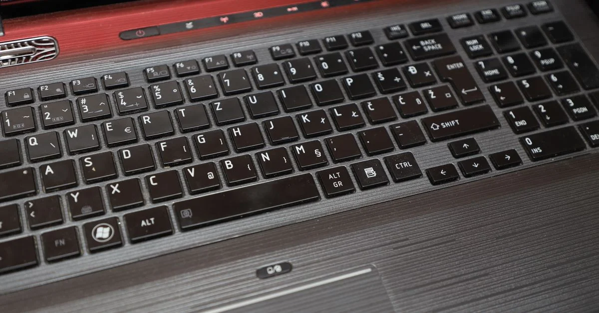 Vue détaillée d'un clavier d'ordinateur portable Qosmio vintage avec une disposition de touches européenne distincte.